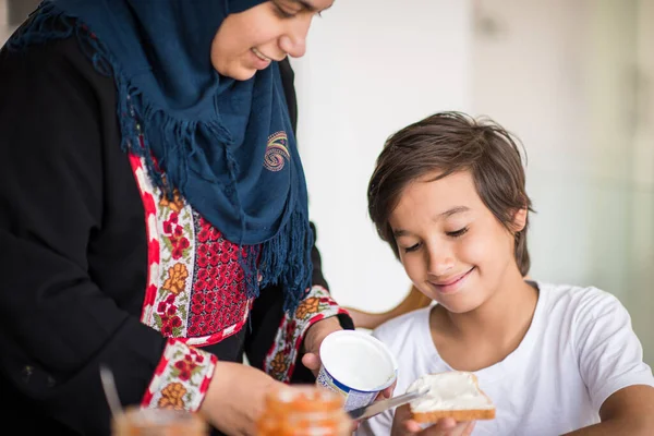 Mujer musulmana tradicional con hijo en la cocina —  Fotos de Stock