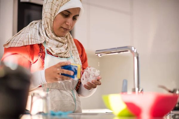 Mulher tradicional muçulmana limpeza na cozinha — Fotografia de Stock