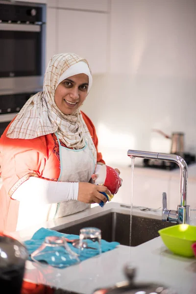 Moslim traditionele vrouw schoonmaken in de keuken — Stockfoto