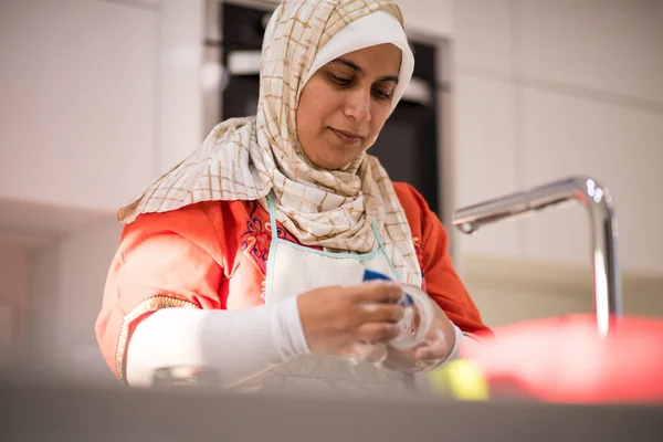 Moslim traditionele vrouw schoonmaken in de keuken — Stockfoto