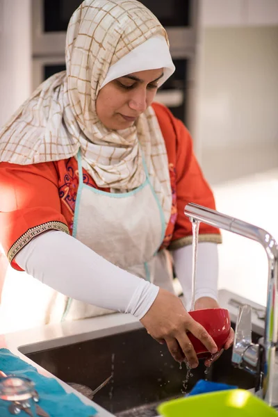 Muslimská tradiční žena úklid v kuchyni — Stock fotografie