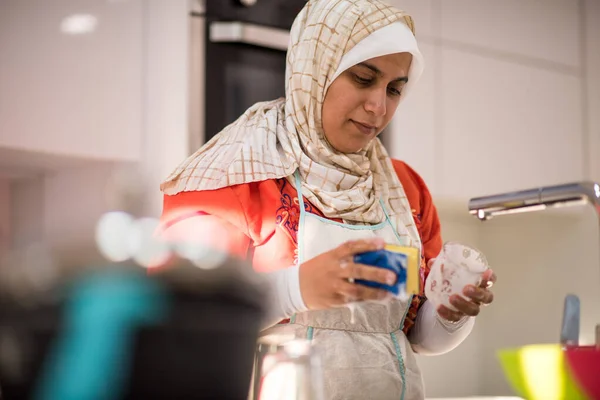 Μουσουλμανική παραδοσιακή γυναίκα καθαρισμού στην κουζίνα — Φωτογραφία Αρχείου