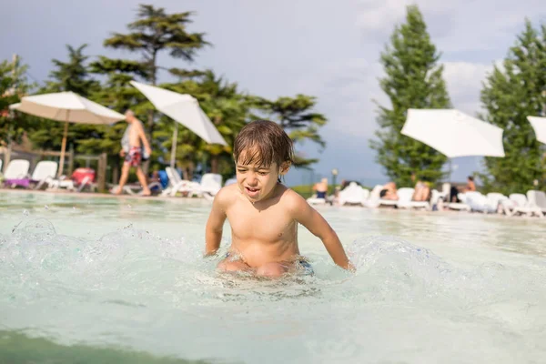 Junge Kind planscht im Schwimmbad und hat Spaß an Freizeitaktivität lizenzfreie Stockbilder