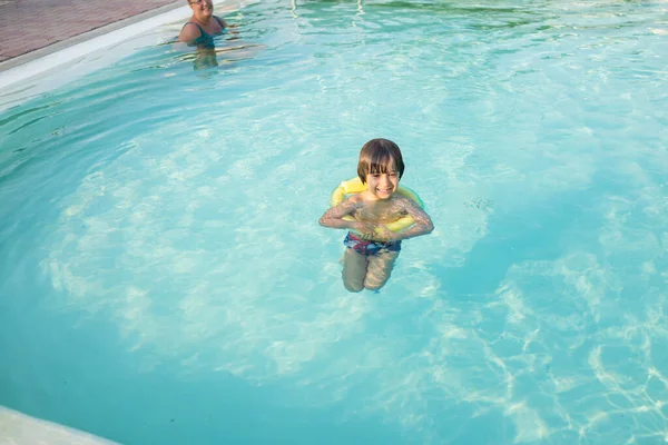 Young boy kid child splashing in swimming pool having fun leisure activity Stock Image