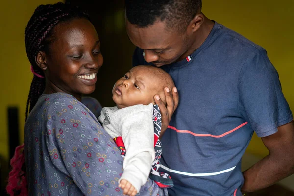 Fiatal fekete család boldog anya és apa kezében baba — Stock Fotó