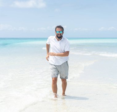 Bir adam güzel tropikal plajın tadını çıkarıyor.