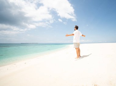 Bir adam güzel tropikal plajın tadını çıkarıyor.