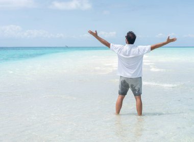 Bir adam güzel tropikal plajın tadını çıkarıyor.