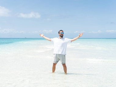 Bir adam güzel tropikal plajın tadını çıkarıyor.