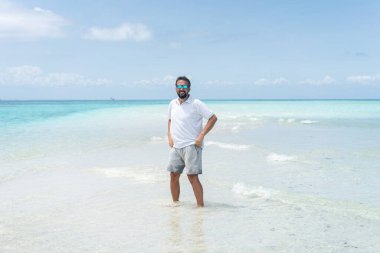 Bir adam güzel tropikal plajın tadını çıkarıyor.