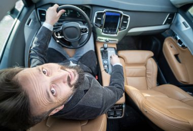 Lüks arabadaki erkek sürücünün geniş açısı