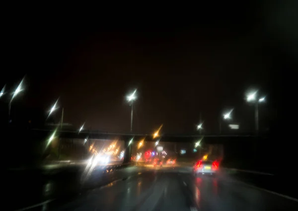 Samochody ruch na miasto deszcz noc ulica — Zdjęcie stockowe
