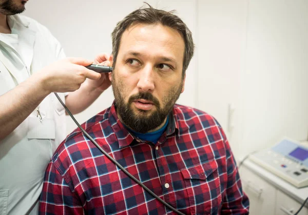 Médico no hospital verificando a orelha do paciente — Fotografia de Stock