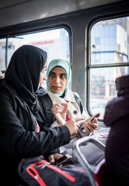 Anne ve kızı şehirde toplu taşıma araçlarına biniyor.
