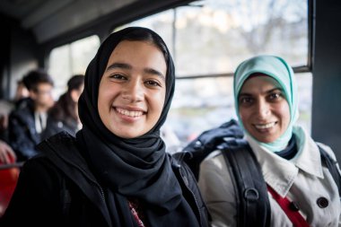 Anne ve kızı şehirde toplu taşıma araçlarına biniyor.