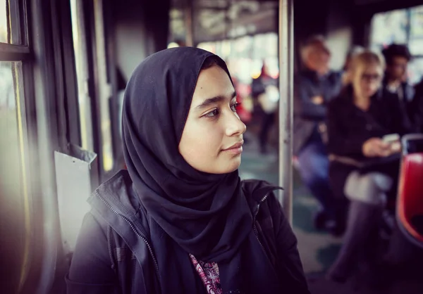 Chica de Oriente Medio montando transporte público en la ciudad —  Fotos de Stock