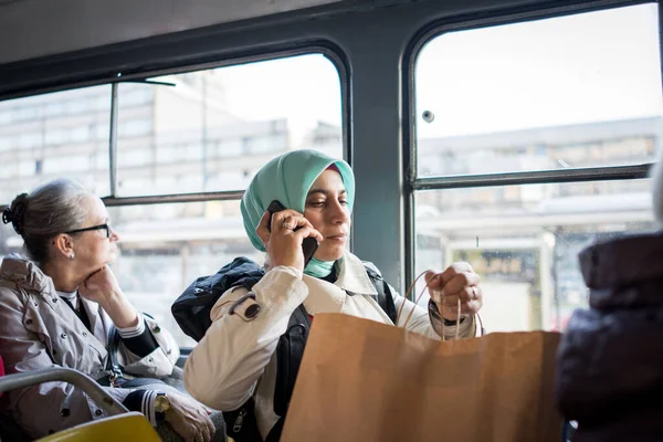 Muselman kvinna ridning kollektivtrafik i stad — Stockfoto