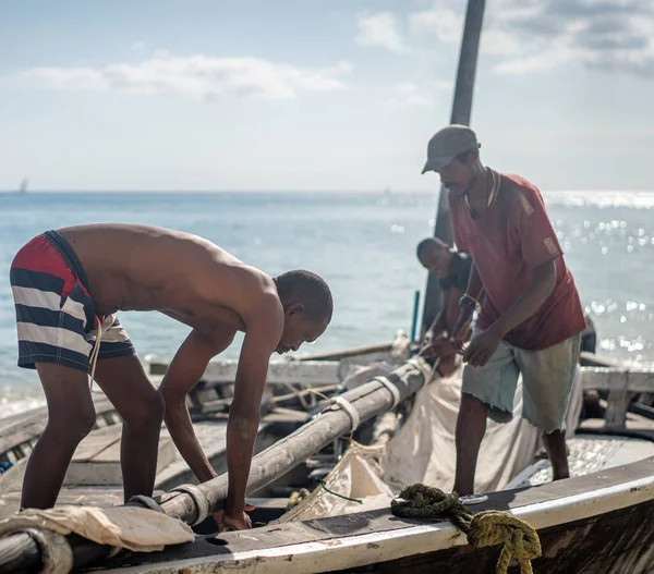 Afrikaanse mannen werken op boot met zeil — Stockfoto