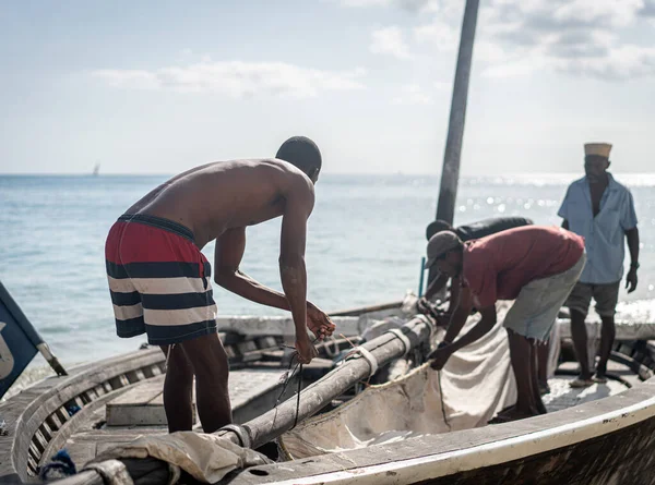 Afrikaanse mannen werken op boot met zeil — Stockfoto