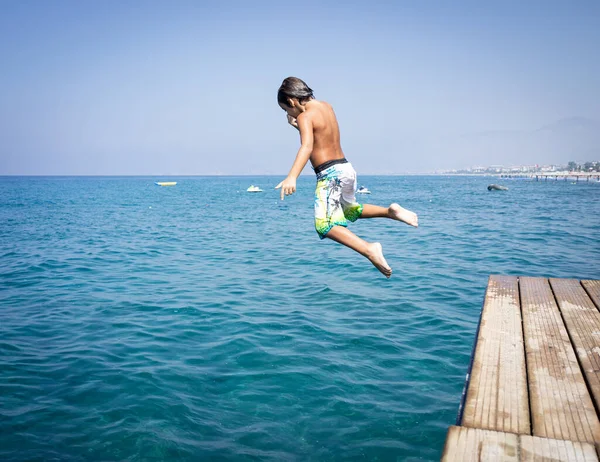 Piccolo ragazzo carino sul molo del mare godendo l'estate — Foto Stock