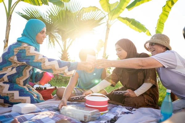 Família feliz desfrutando de piquenique na praia — Fotografia de Stock