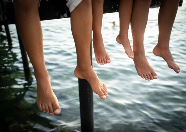 Felice giovani amici godendo sul molo in mare — Foto Stock