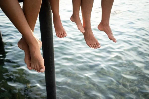 Happy young friends enjoying on pier at sea — Stock Photo, Image