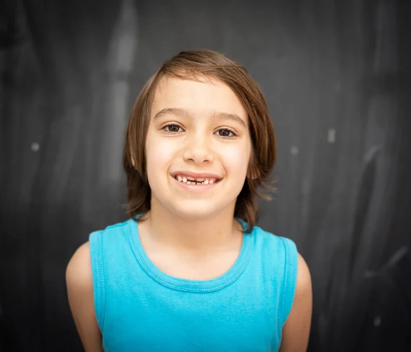 Menino bonito na frente do quadro de sala de aula — Fotografia de Stock