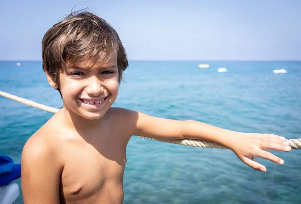 Piccolo ragazzo carino sul molo del mare godendo l'estate — Foto Stock