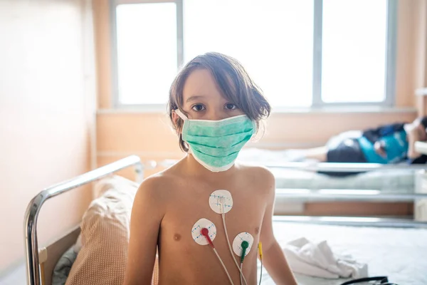 Liten söt pojke på sjukhus i sängen — Stockfoto