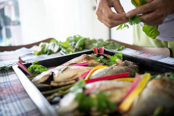 Preparando deliciosos pescados con verduras Imagen De Stock