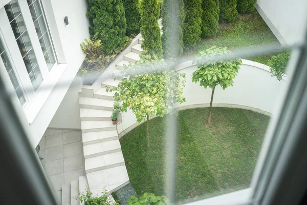 Schöne Fenstersicht auf den grünen Garten Hinterhof — Stockfoto