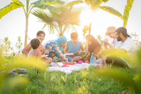 Familia feliz disfrutando de un picnic en la playa — Foto de Stock