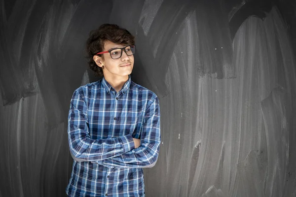 Adolescent garçon avec lunettes en face de salle de classe conseil — Photo