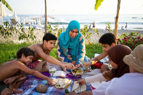 Familia feliz disfrutando de un picnic en la playa —  Fotos de Stock