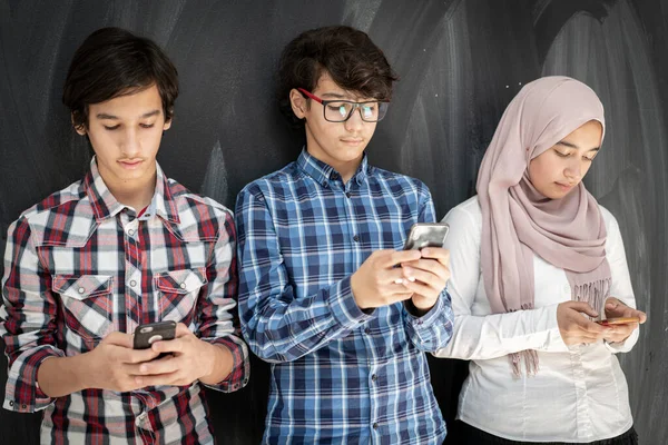 Group of multy ethnic kids in classroom with smartphones — Stockfoto