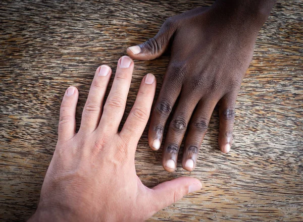 Duas mãos branco e preto fazendo equipe — Fotografia de Stock