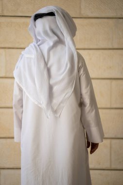 Geleneksel beyaz elbiseli yetişkin bir Müslüman adam kameraya bakar ve duygularını ifade eder. Geçmişinde yaşlı bir erkek şeyh var. Yüksek kalite fotoğraf