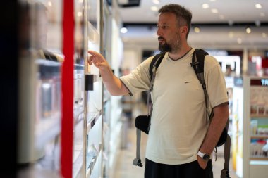 Havaalanından parfüm alışverişi yapan sakallı bir adamın profili. Yüksek kalite fotoğraf