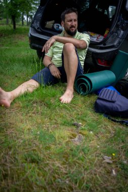 Ormandaki bir arabanın bagajında dinlenen sıradan bir adam. Yüksek kalite fotoğraf