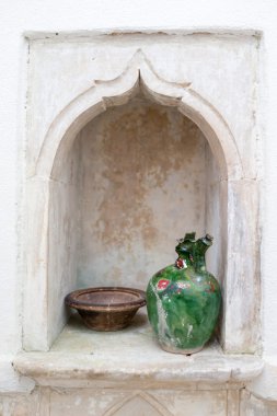 Fenerli bir bardak ve duvarında metal bir tencere.