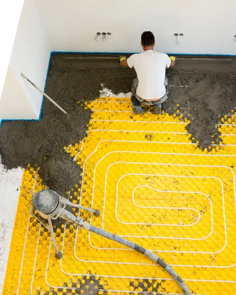 Manual worker installing underfloor heating — Stock Photo, Image