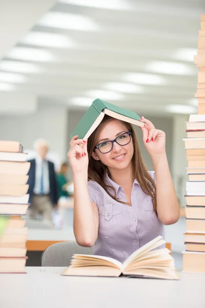 Menina bonita estudando na biblioteca da faculdade — Fotografia de Stock