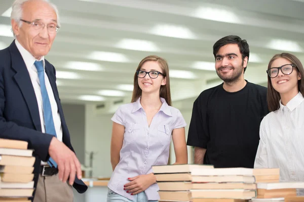 Professore senior che tiene lezioni ai giovani studenti — Foto Stock