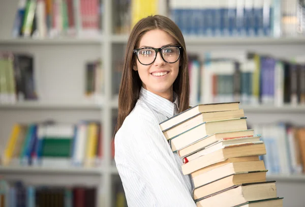 Gelukkig jong meisje op college library die stapel boeken — Stockfoto