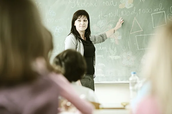 Profesor en la sala de la escuela que tiene actividad educativa con niños —  Fotos de Stock