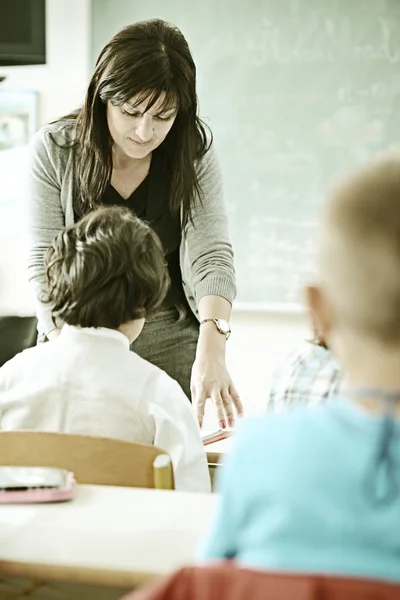 Profesor en la sala de la escuela que tiene actividad educativa con niños —  Fotos de Stock