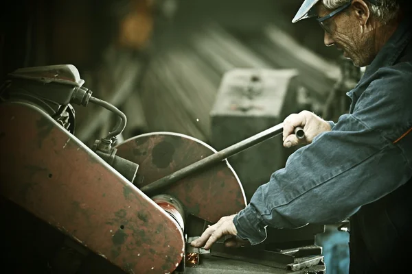 Arbeiter schneidet Eisen mit professionellem Werkzeug — Stockfoto