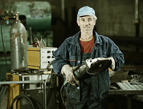 Arbetaren skärande järn med professionella verktyg — Stockfoto