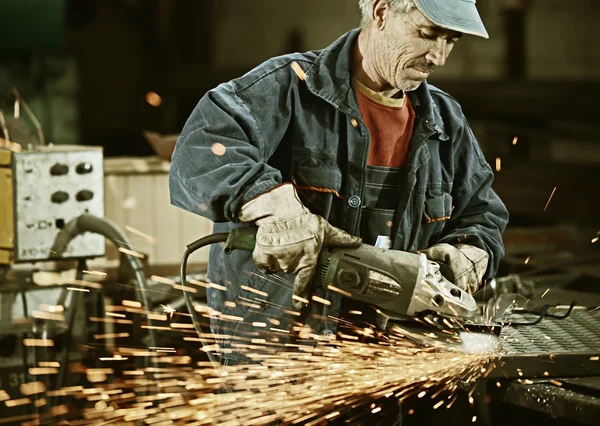 Arbeiter schneidet Eisen mit professionellem Werkzeug — Stockfoto